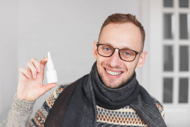 Pozitivní chlap ukazuje nosní nebo oční sprej, plastová láhev v ruce - Fotografie, Obrázek