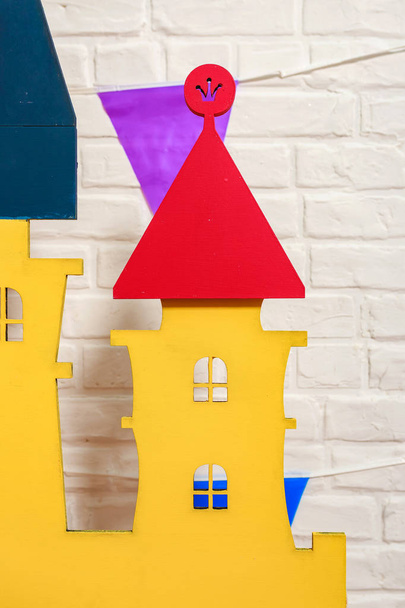 Details of the toy castle close-up. Toy castle is the backdrop for a photo shoot for a birthday. Photo zone with decorations for the birthday celebration for kids. Children's photo Studio for kids. Cardboard colorful children's castle - Photo, Image