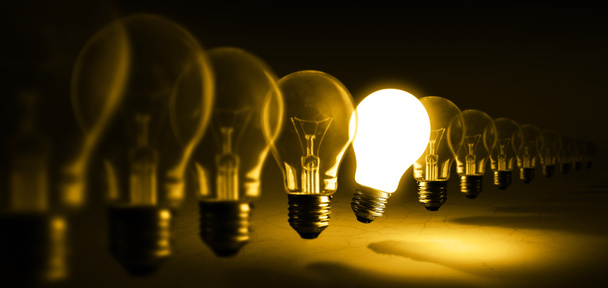 Glowing light bulb on orange background, idea concept - Photo, Image