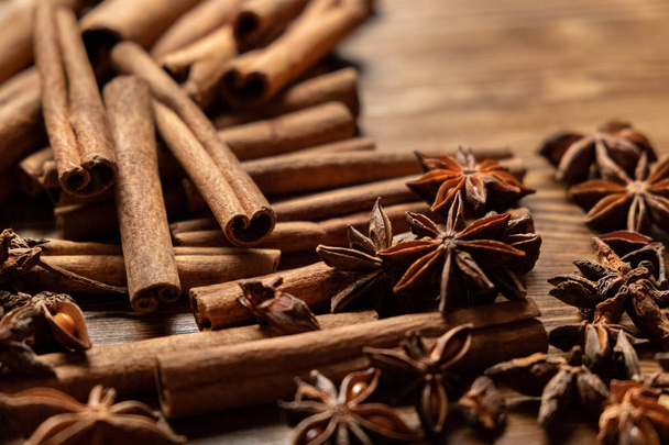 Star anise, cinnamon and roasted coffee beans. Aromatic spices on wooden background. Top view. Close up. Seasoning ingredients for cooking or baking - Photo, Image