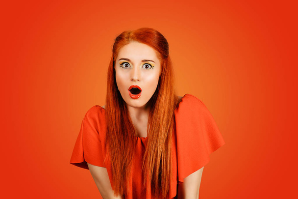 A surprised woman is surprised. Closeup portrait of woman looking surprised in mouth full open mouth open isolated red background. Positive emotional sensitivity of body language of facial expression. - Fotografie, Obrázek