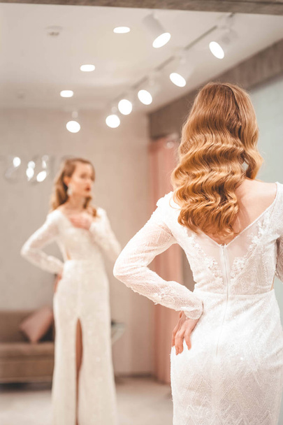The girl tries on an elegant wedding dress - Valokuva, kuva