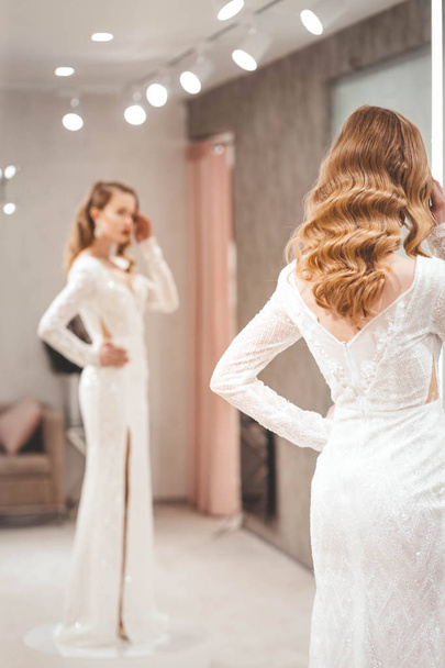 The girl tries on an elegant wedding dress - Foto, Bild