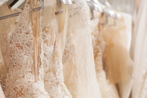 Large selection of dresses in the wedding salon. - Fotoğraf, Görsel
