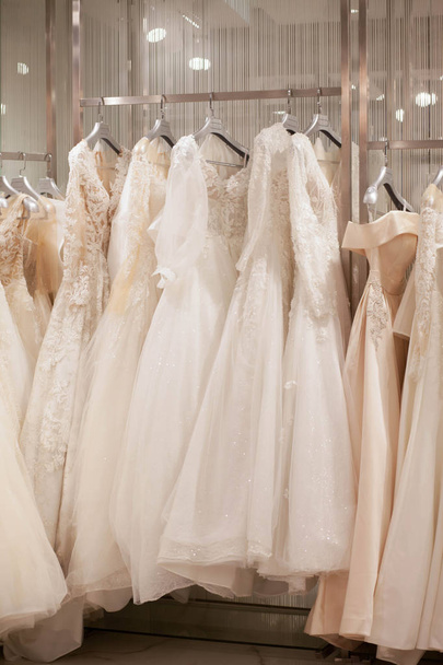 Elegáns ruhák az esküvői szalonban. Az esküvői ruhák kiválasztása a boltban - Fotó, kép