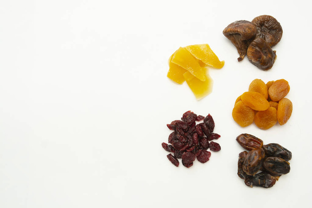 Mix of dried fruits heaps isolated on white background with copy space - figs, dates, mango, cranberries. Breakfast or snack, healthy food. - Фото, изображение