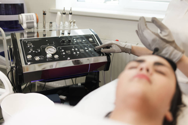 Medico cosmetologo utilizza il dispositivo per le procedure cosmetiche
. - Foto, immagini