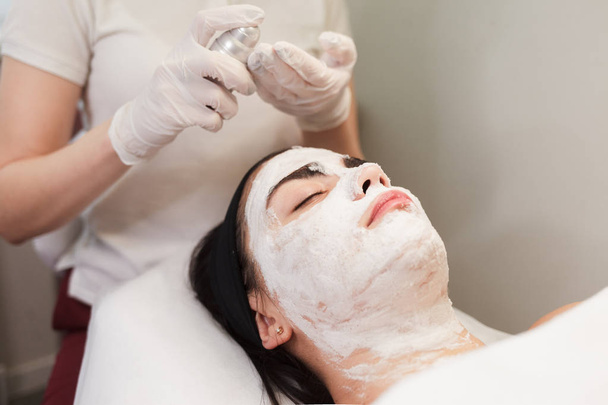 Cosmetologo applica schiuma sul viso di una ragazza
 - Foto, immagini