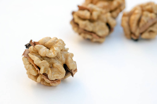 Peeled walnut closeup. Golden walnut kernel on a white background. Healthy foods. - Photo, Image