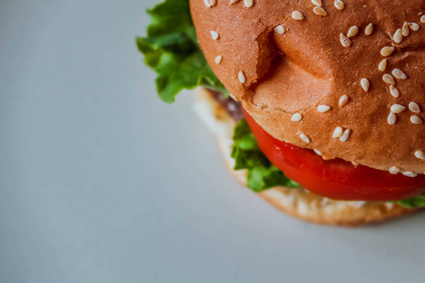 Domowej roboty cheeseburger na białym tle z przestrzenią, widok z boku. Burger z bliska. - Zdjęcie, obraz