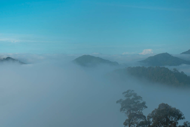 ландшафт, туман і хмарна гірська долина, ранковий туман, сонце сходить . - Фото, зображення