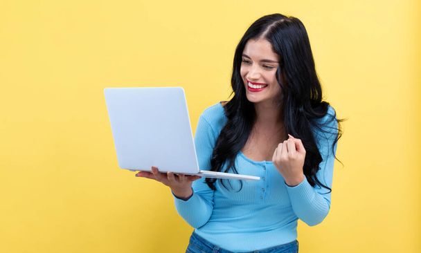 Young woman with a laptop computer with successful pose - Foto, imagen