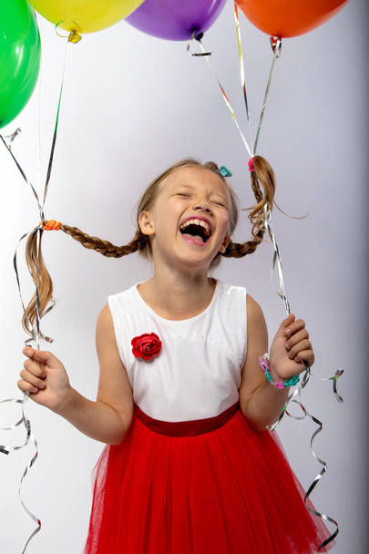the little girl laughs out loud holds in hands balloons - Foto, Bild