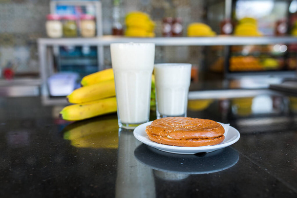 Banana juice smoothie milk shake with some ingredients. Blender with full of milk, banana and honey. Smoothies maker. Milk shaker - Photo, Image