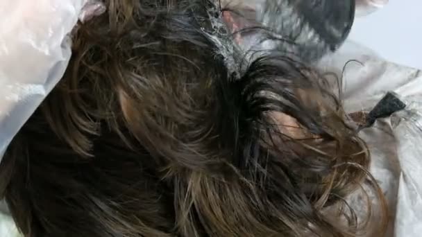 Szare włosy u korzeni kobiet, które sama farbuje włosy specjalną farbą i pędzlem w domu - Materiał filmowy, wideo