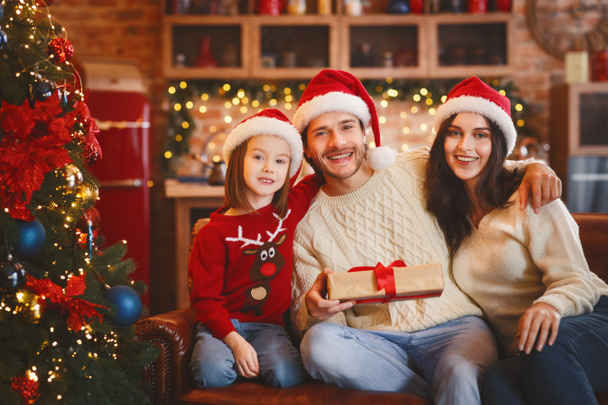 Famille aimante posant avec des cadeaux de Noël sur fond de maison décorée
 - Photo, image