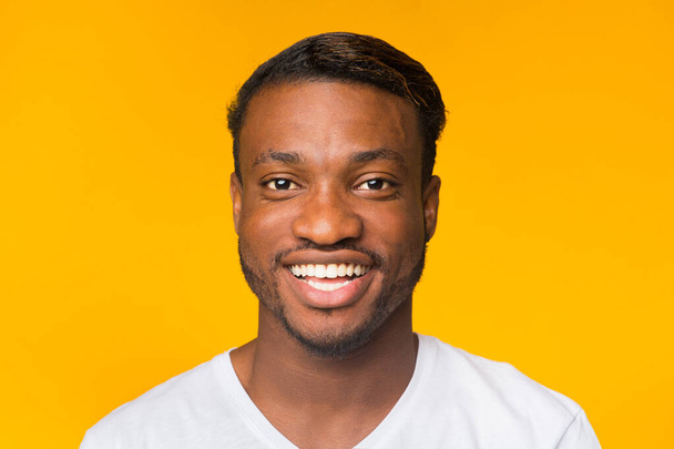 Portrait de homme noir souriant debout sur fond jaune
 - Photo, image