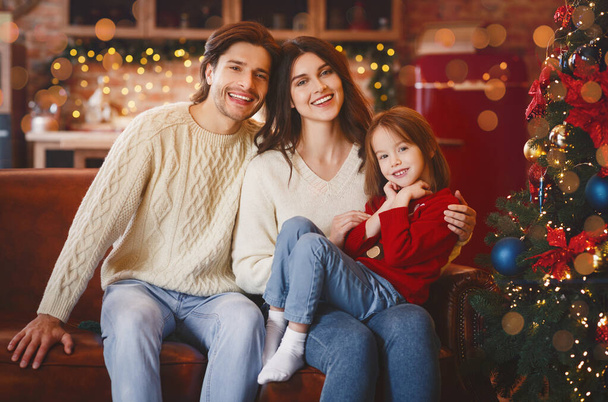 Friendly family getting ready for Christmas, sitting on sofa - 写真・画像