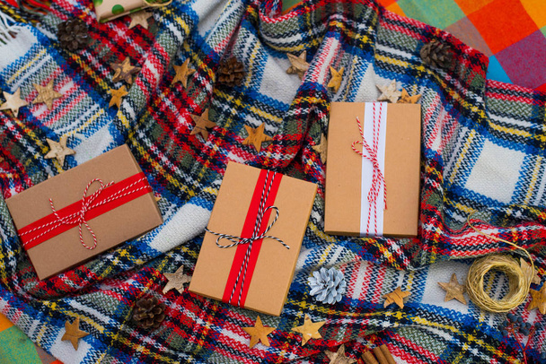 Karácsonyi háttér ajándékdobozokkal, kötél hasítékokkal, papír rools és dekorációk skót kockás otthon. Készülődés az ünnepekre. Felülnézet - Fotó, kép