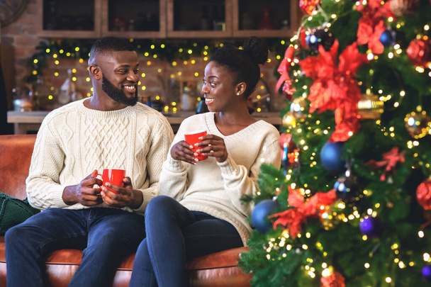 Romantikus fekete pár kávézik otthon, karácsony estéjét ünneplik - Fotó, kép
