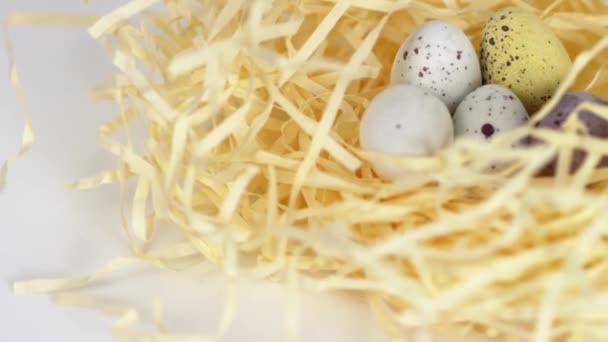 Tiro de ovos de chocolate salpicados coloridos em um ninho, girando
 - Filmagem, Vídeo