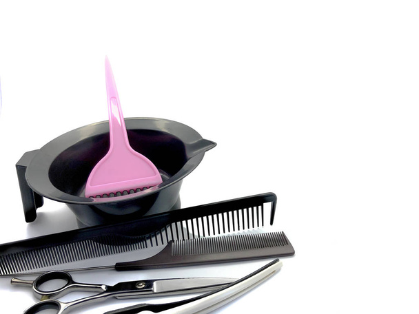 Bowl for paint, comb, pink brush and scissors isolated on a white background. Set of professional hairdressing tools for hair coloring. Composition of tools for a beauty salon. - Photo, Image