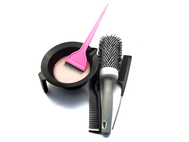 Schale für Farbe, Haarbürste und Pinsel rosa isoliert auf weißem Hintergrund. Set professioneller Friseurwerkzeuge zur Haarfärbung. Zusammenstellung von Werkzeugen für einen Schönheitssalon. Blauer Barbierumhang. - Foto, Bild
