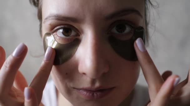 Kosteuttava ja kiristävä iho silmien alla korealaisen kosmetiikan avulla - kauniita läiskiä turvotuksen poistamiseksi. Nosto menettely, söpö valkoihoinen tyttö
 - Materiaali, video