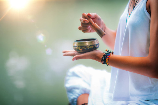 Close up image of womans hands holding Tibetan bowl by the Water  - Photo, Image