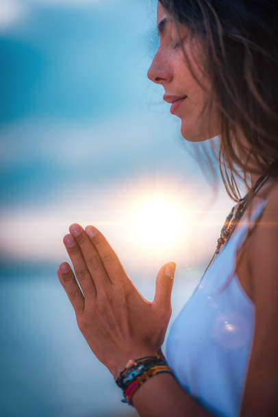 Nuori nainen meditoi silmät kiinni, harjoittelee joogaa kädet rukousasennossa
.   - Valokuva, kuva
