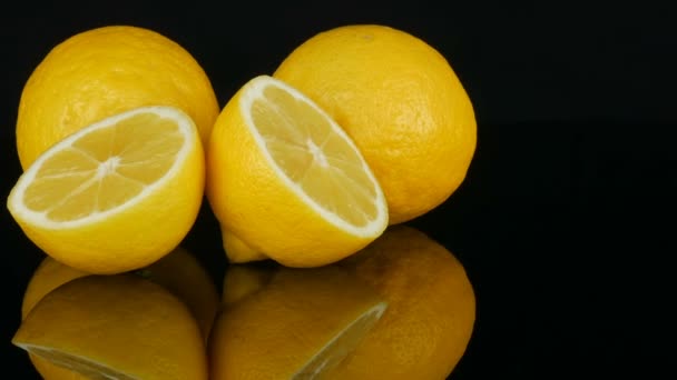 Ripe fresh juicy yellow lemon on black background - Footage, Video