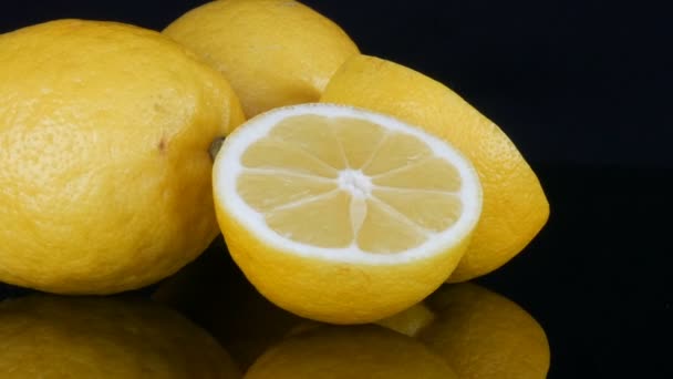 Olgun taze sulu sarı limon siyah arkaplanda dönüyor - Video, Çekim