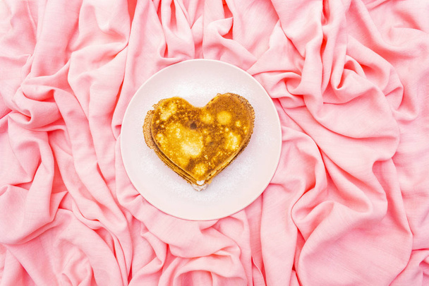 Panqueques en forma de corazón para el desayuno romántico en plato rosado. Concepto de Shrovetide (carnaval). Sobre fondo de lino de tela rosa, vista superior
 - Foto, Imagen