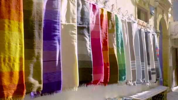 Kleurrijke sjaals opgehangen aan een muur in Essaouira, Marokko - Video