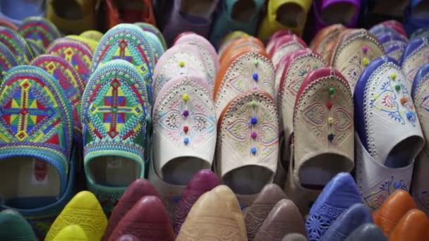 Handheld close up shot tracking across a display of colourful Moroccan Balgha slippers in Marrakesh - Footage, Video