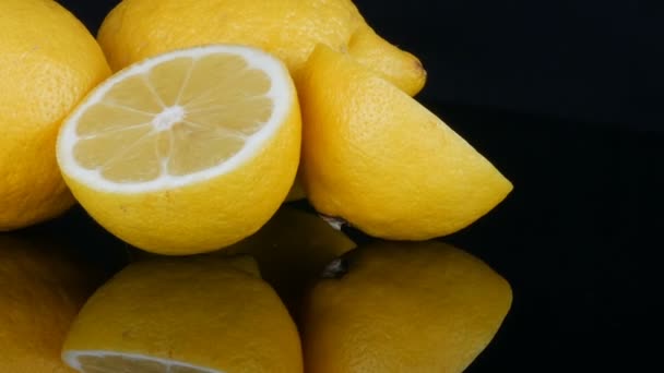 Zralé čerstvé šťavnaté žluté citron na černém pozadí otáčet - Záběry, video