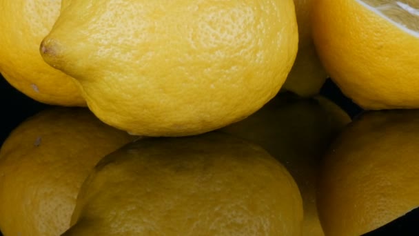 Dojrzałe świeże soczyste żółta cytryna na czarnym tle - Materiał filmowy, wideo