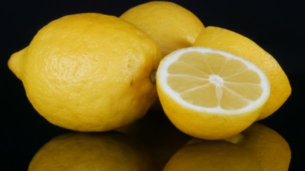 reife frische saftige gelbe Zitrone auf schwarzem Hintergrund drehen - Filmmaterial, Video