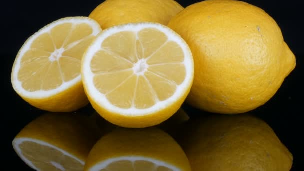 Rijp verse sappige gele citroen op zwarte achtergrond - Video