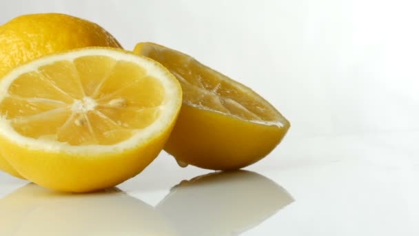 Zralé čerstvé šťavnaté žluté citron na bílém pozadí. - Záběry, video