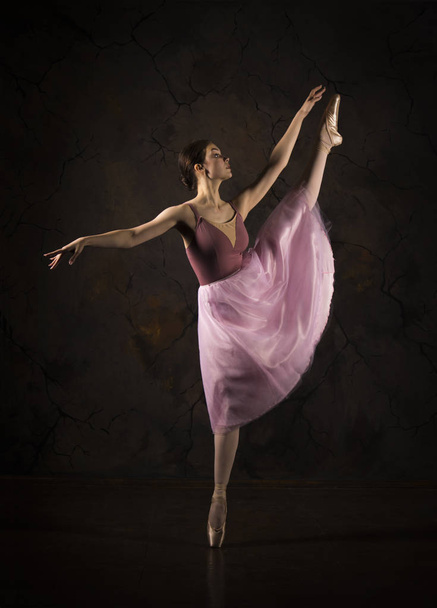 A slender girl in a pink skirt and beige top dancing ballet. - Fotoğraf, Görsel