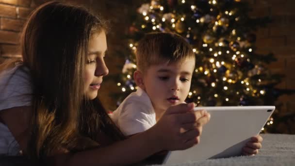 Sister with little brother use a digital tablet - Filmagem, Vídeo