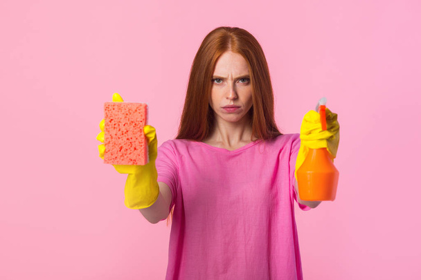 beautiful young woman with red hair in yellow rubber gloves on a pink background - Fotografie, Obrázek