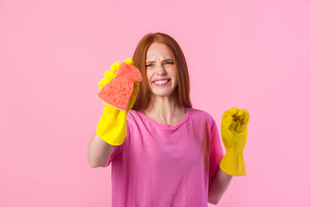 beautiful young woman with red hair in yellow rubber gloves on a pink background - Foto, immagini