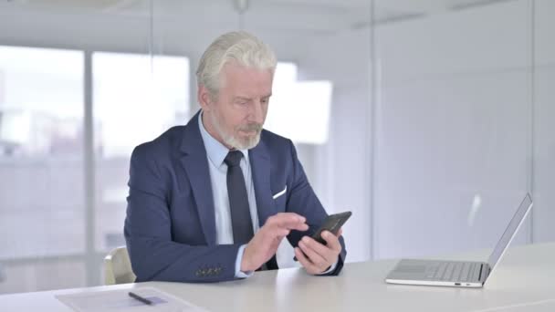 Middle Aged Businessman Celebrating Success on Smartphone  - Video, Çekim