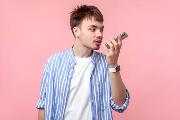 Voice assistant. Portrait of brown-haired man talking on phone,  - 写真・画像