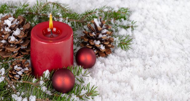 Burning Candle and Holiday Decor on Snow - Photo, Image