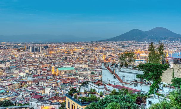 Неаполь в Италии с горой Везувий в сумерках видно с холма Вомеро
 - Фото, изображение