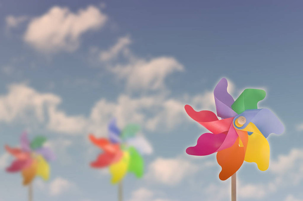 Moulin à vent jouets sur ciel bleu soleil nuages blanc fond. focus sélectif
 - Photo, image