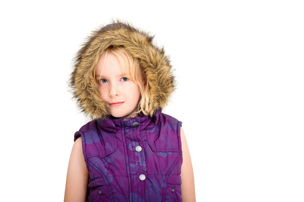 Beautiful young blonde girl wearing a fur lined hood on a white studio background - Fotoğraf, Görsel